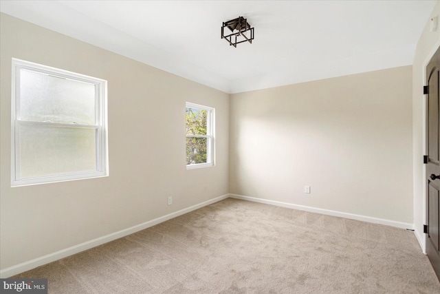 carpeted empty room featuring baseboards