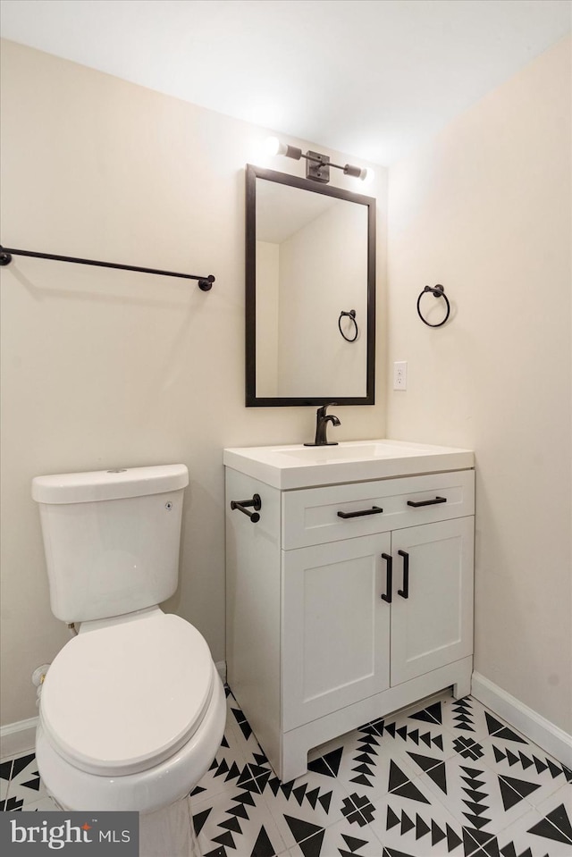 bathroom featuring vanity, toilet, and baseboards