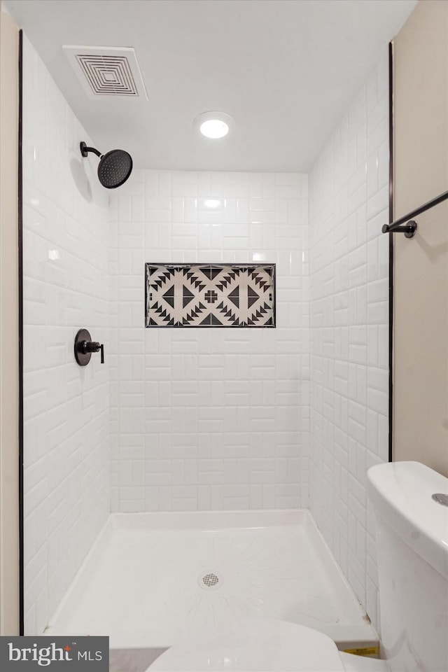 full bathroom with toilet, a tile shower, and recessed lighting