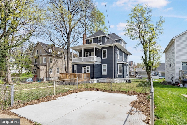 back of property featuring a balcony, a chimney, and a residential view