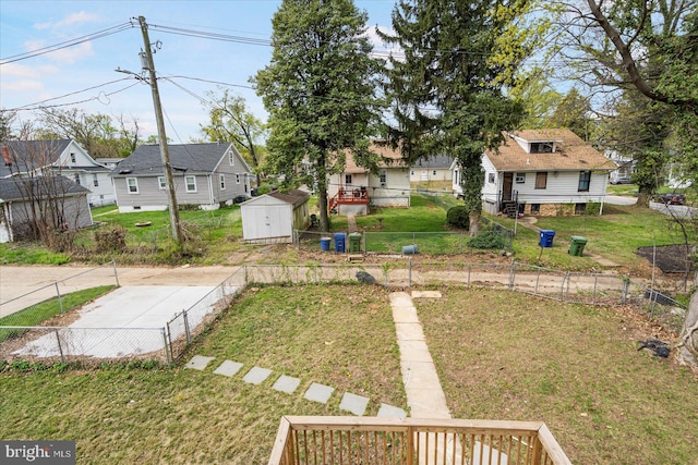 view of yard featuring a shed, a residential view, and an outbuilding