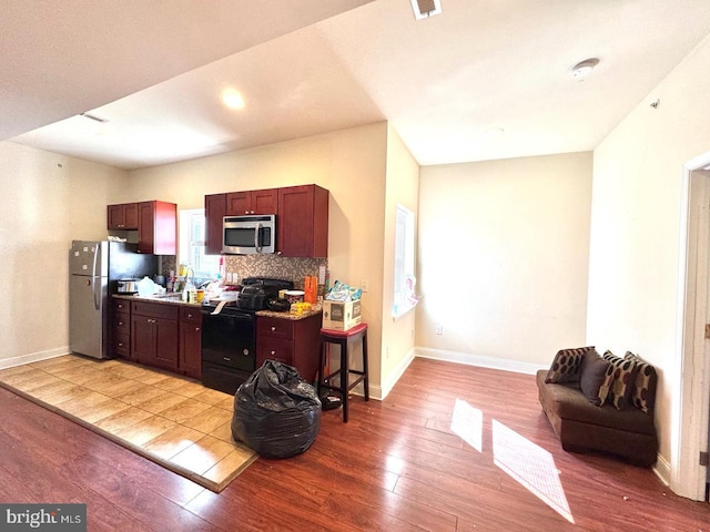 1431 N 17th St, Philadelphia, PA 19121 - kitchen with appliances with stainless steel finishes, light wood finished floors, baseboards, backsplash, and open floor plan