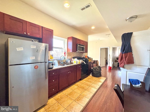 1431 N 17th St, Philadelphia, PA 19121 - kitchen with appliances with stainless steel finishes, a sink, dark brown cabinets, decorative backsplash, and light wood-type flooring