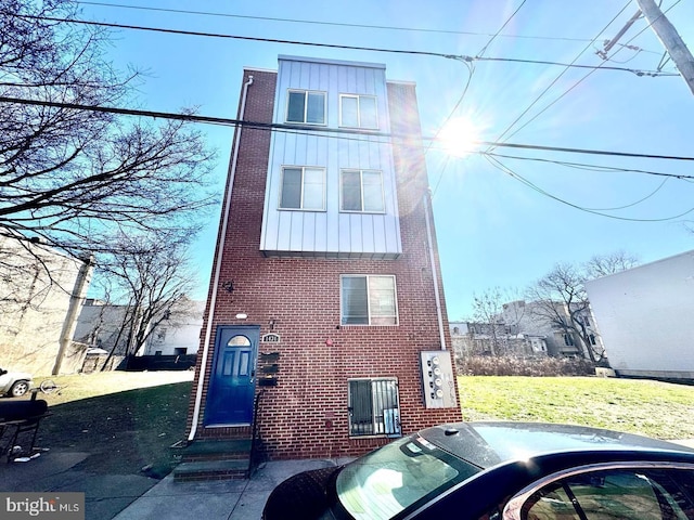 1431 N 17th St, Philadelphia, PA 19121 - view of front of home with brick siding, board and batten siding, and a front lawn