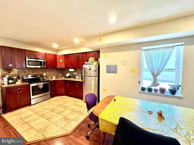 1431 N 17th St, Philadelphia, PA 19121 - kitchen with appliances with stainless steel finishes, backsplash, dark brown cabinets, light wood-style flooring, and recessed lighting