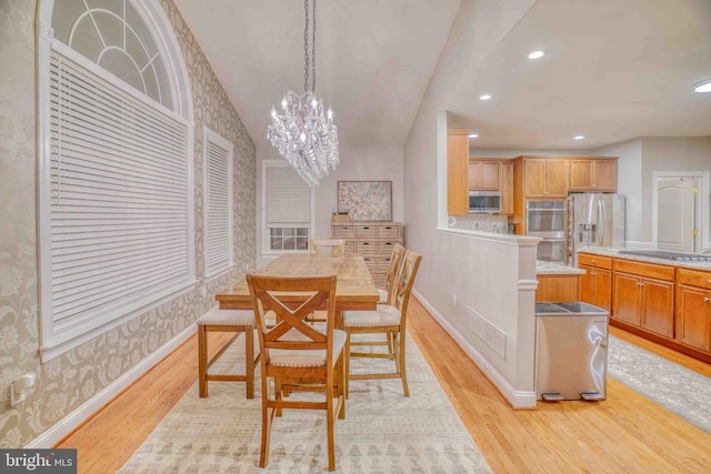 dining room featuring wallpapered walls, light wood-type flooring, recessed lighting, a chandelier, and baseboards