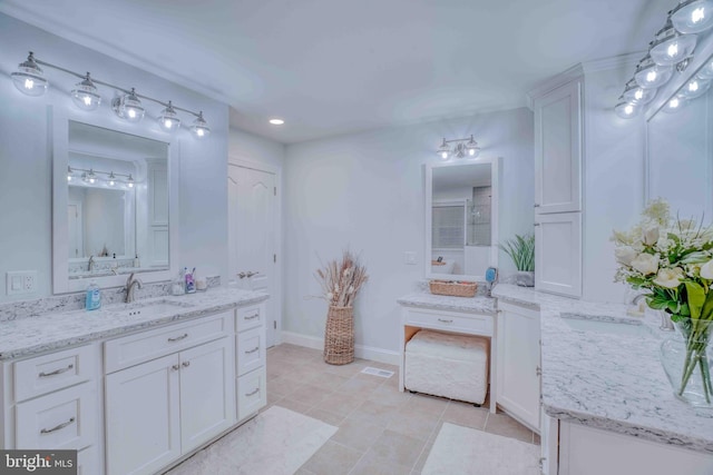bathroom with vanity, tile patterned floors, and baseboards