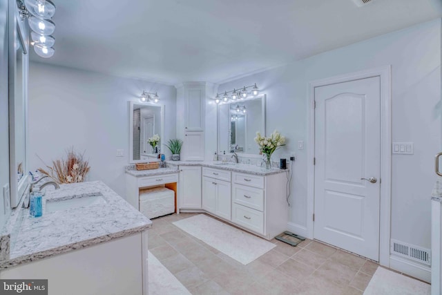 bathroom featuring two vanities and tile patterned floors