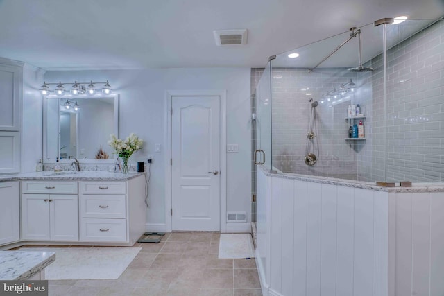 bathroom with a shower stall, vanity, tile patterned floors, baseboards, and recessed lighting