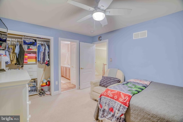 bedroom with carpet floors, a closet, a ceiling fan, ensuite bath, and baseboards
