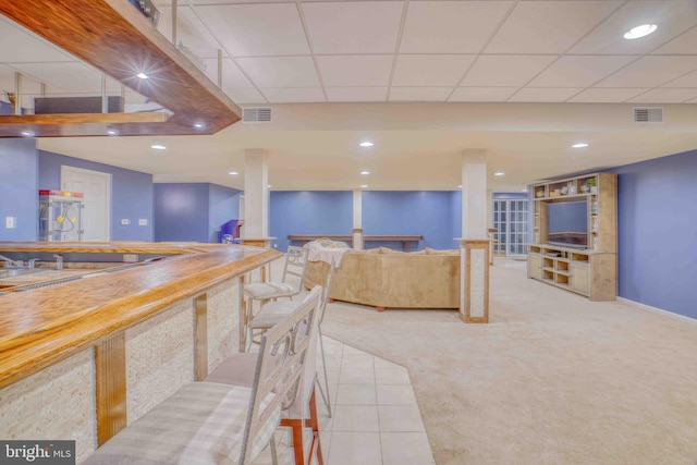 carpeted dining area with bar area, recessed lighting, baseboards, and tile patterned flooring