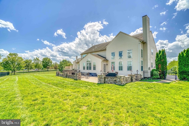back of house with a patio, a chimney, and a gate