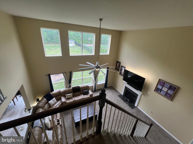 23 Cardinal Ln, Sicklerville, NJ 08081 - staircase featuring carpet, baseboards, ceiling fan, a fireplace with flush hearth, and a towering ceiling