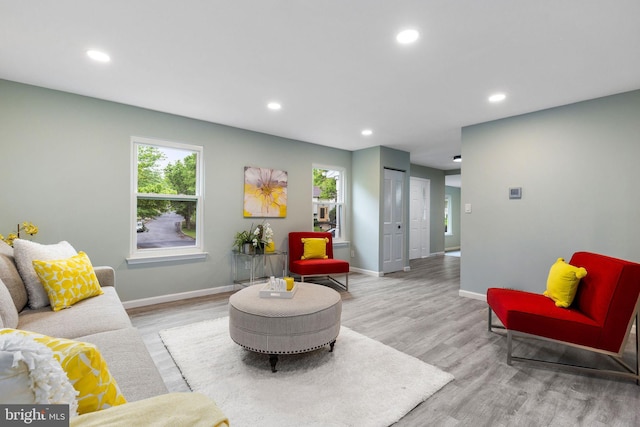living room featuring recessed lighting, baseboards, wood finished floors, and healthy amount of natural light