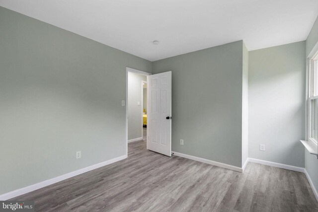 empty room featuring wood finished floors and baseboards