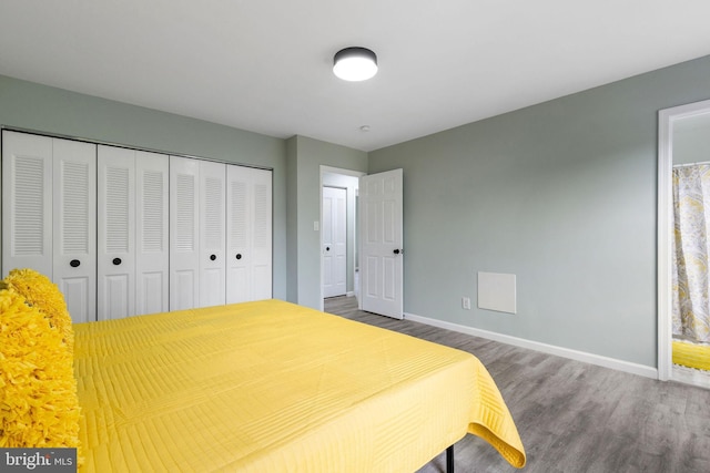 bedroom with wood finished floors, baseboards, and a closet