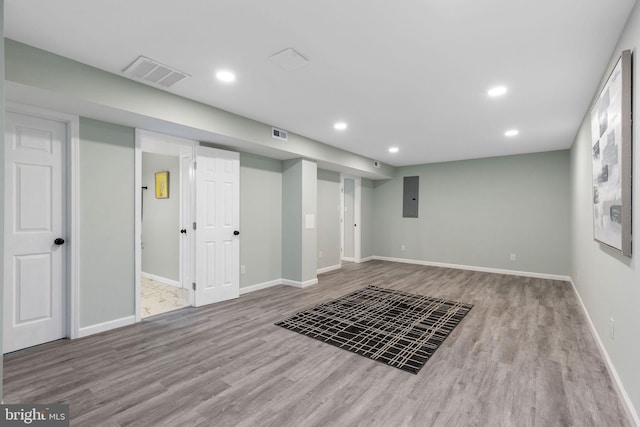 finished basement with wood finished floors, recessed lighting, baseboards, and electric panel