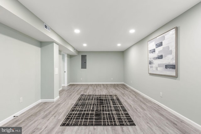 finished below grade area with recessed lighting, wood finished floors, baseboards, and electric panel