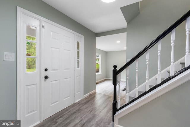 foyer entrance with wood finished floors, stairway, baseboards, and recessed lighting