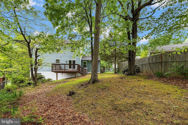 view of yard with fence and a deck