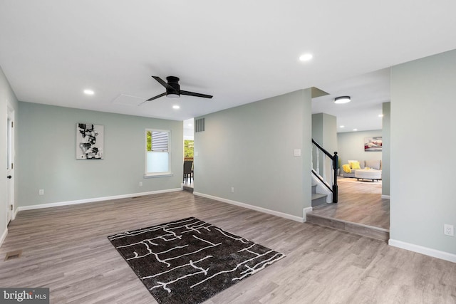 unfurnished living room with ceiling fan, wood finished floors, stairs, baseboards, and recessed lighting