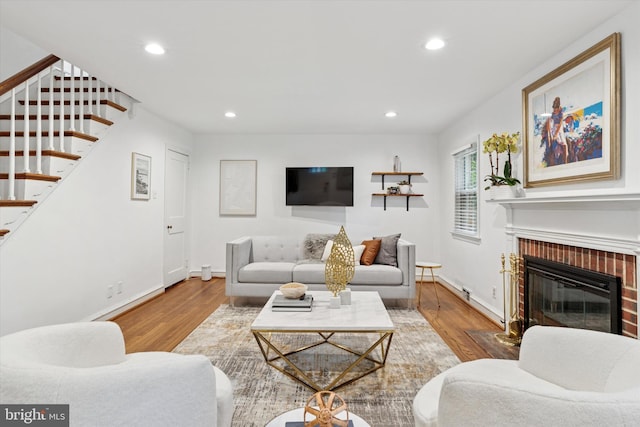 living area with wood finished floors, stairs, recessed lighting, a fireplace, and baseboards