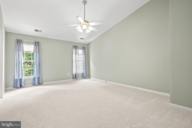 spare room with light carpet, ceiling fan, lofted ceiling, and baseboards