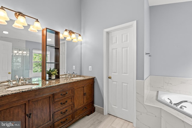 full bath featuring double vanity, a garden tub, baseboards, and a shower