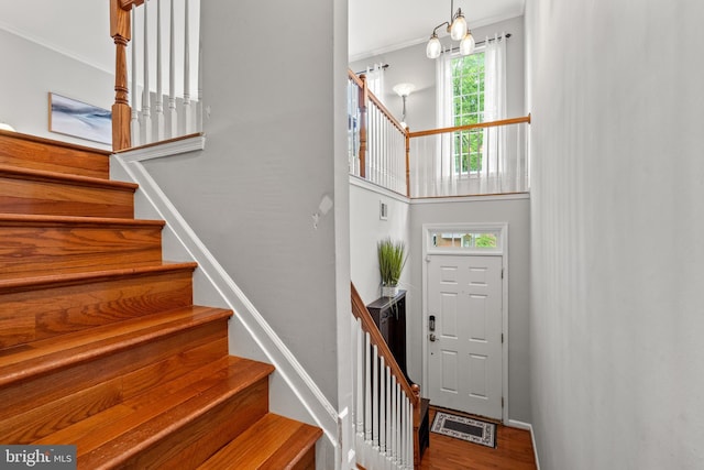 stairs featuring ornamental molding, wood finished floors, and baseboards