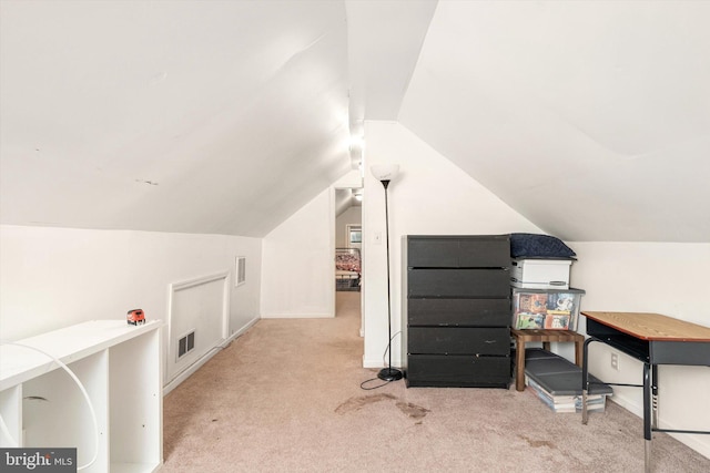 carpeted office space with lofted ceiling and baseboards