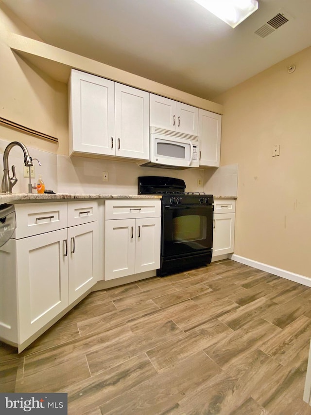 704 Dresher Woods Dr, Dresher, PA 19025 - kitchen featuring white microwave, black gas range, white cabinetry, dishwashing machine, and light wood-style flooring