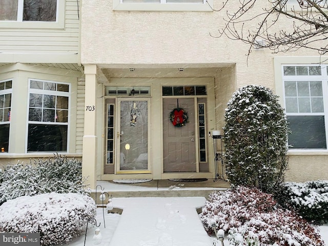 704 Dresher Woods Dr, Dresher, PA 19025 - snow covered property entrance featuring stucco siding and covered porch