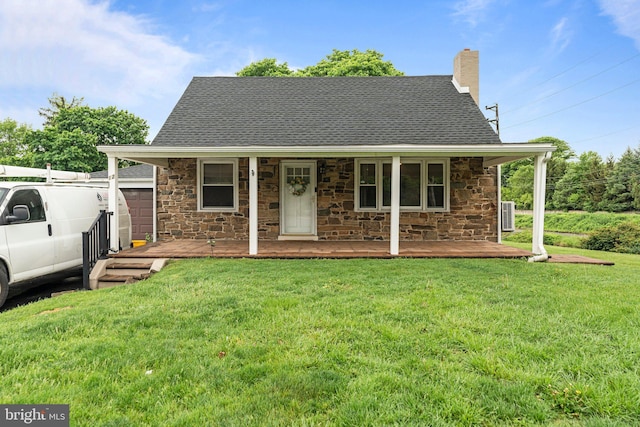 view of front of home with stone siding, a chimney, a porch, and a front yard