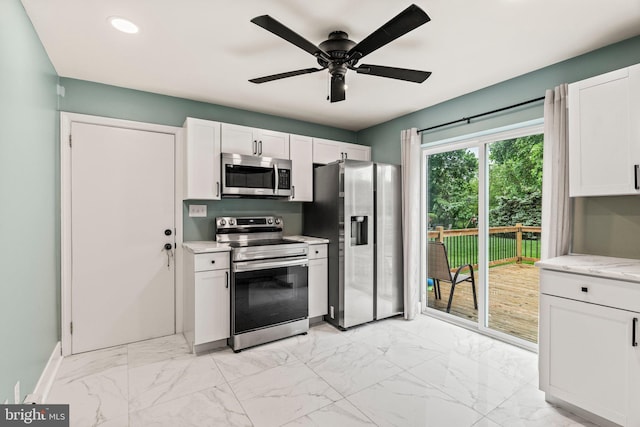 kitchen featuring appliances with stainless steel finishes, light marble finish floors, white cabinetry, a ceiling fan, and recessed lighting