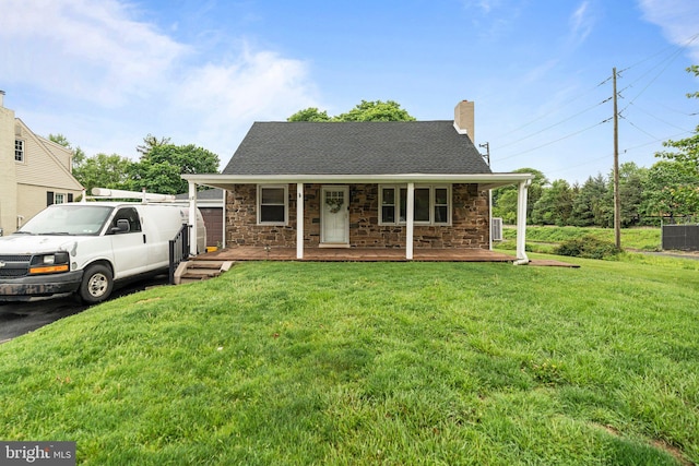 view of front of house featuring covered porch, stone siding, a chimney, and a front yard