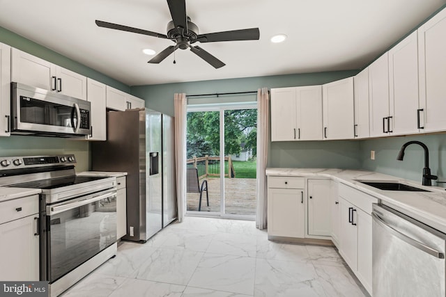 kitchen with appliances with stainless steel finishes, a sink, light marble finish flooring, recessed lighting, and white cabinets