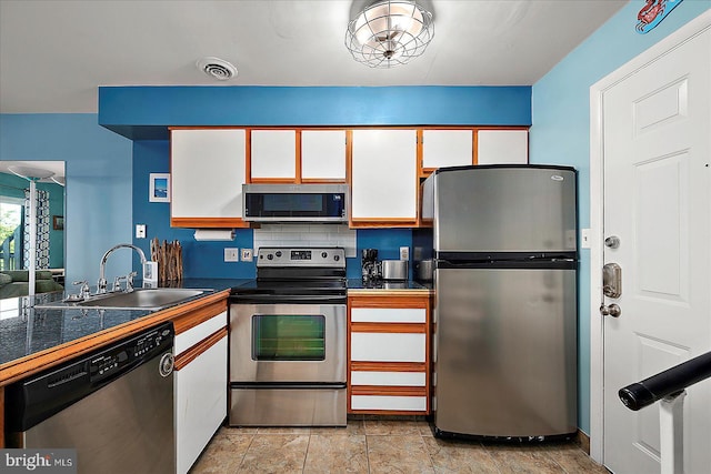 104 127th St Unit 326B, Ocean City, MD 21842 - kitchen with appliances with stainless steel finishes, a sink, white cabinetry, tile countertops, and light stone finish floors