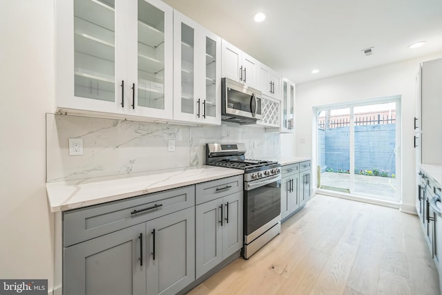 1309 S 32nd St, Philadelphia, PA 19146 - kitchen featuring appliances with stainless steel finishes, light wood-style floors, decorative backsplash, gray cabinets, and recessed lighting