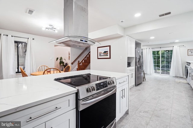 kitchen with stainless steel appliances, island exhaust hood, white cabinets, light stone countertops, and recessed lighting
