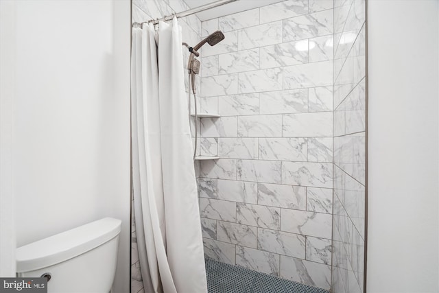 bathroom with toilet and a shower stall