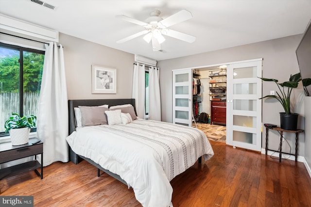 bedroom with wood finished floors, a spacious closet, a closet, and ceiling fan