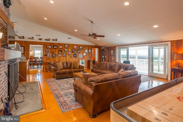 3706 Bestpitch Ferry Rd, Cambridge, MD 21613 - living room featuring a brick fireplace, wooden walls, light wood-type flooring, a ceiling fan, and lofted ceiling