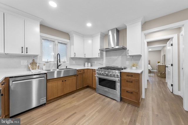 20 Hathaway Dr, Princeton Junction, NJ 08550 - kitchen featuring appliances with stainless steel finishes, wall chimney exhaust hood, light wood finished floors, light countertops, and a sink