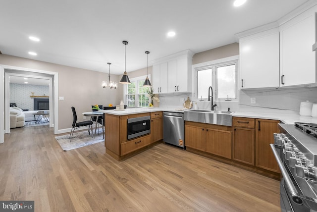 20 Hathaway Dr, Princeton Junction, NJ 08550 - kitchen with appliances with stainless steel finishes, a sink, a peninsula, recessed lighting, and a chandelier