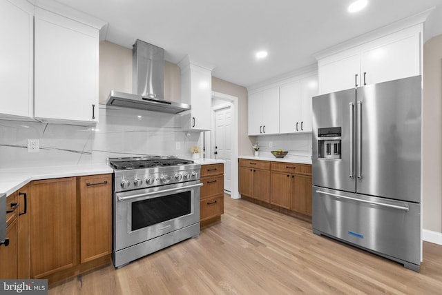 20 Hathaway Dr, Princeton Junction, NJ 08550 - kitchen featuring premium appliances, wall chimney range hood, light wood-style floors, tasteful backsplash, and light countertops