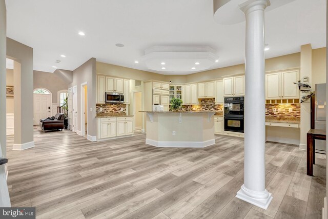 12723 Lady Somerset Ln, Fairfax, VA 22033 - kitchen with cream cabinetry, stainless steel microwave, decorative columns, tasteful backsplash, and a breakfast bar area