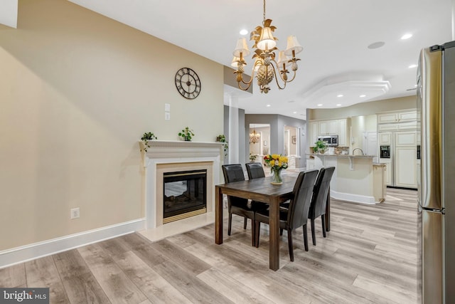 12723 Lady Somerset Ln, Fairfax, VA 22033 - dining room featuring a chandelier, light wood-type flooring, recessed lighting, a fireplace with flush hearth, and baseboards