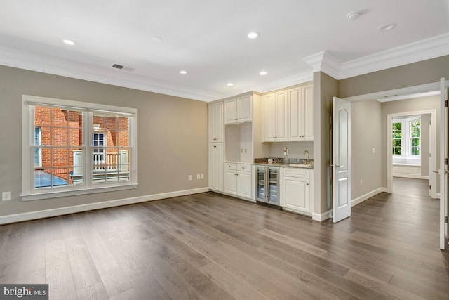 12723 Lady Somerset Ln, Fairfax, VA 22033 - unfurnished living room with wine cooler, ornamental molding, wet bar, baseboards, and dark wood finished floors
