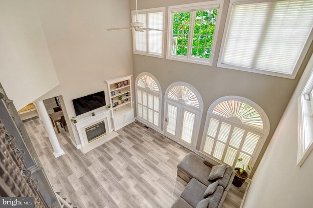 12723 Lady Somerset Ln, Fairfax, VA 22033 - living area with a high ceiling, a glass covered fireplace, light wood finished floors, and ceiling fan