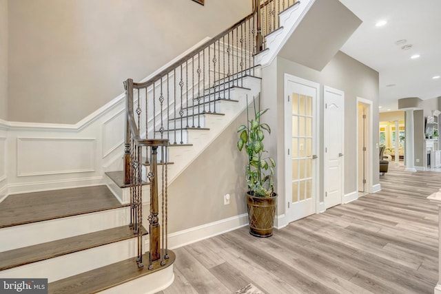 12723 Lady Somerset Ln, Fairfax, VA 22033 - stairway featuring wood finished floors, a decorative wall, ornate columns, recessed lighting, and a wainscoted wall